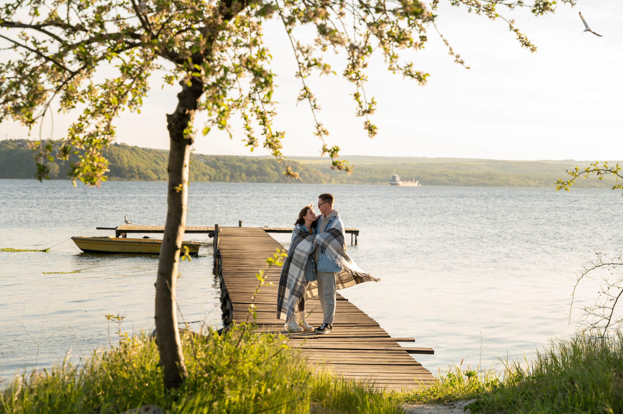 Paar steht auf einem Holzsteg am Bostalsee und blickt über das Wasser – Ausflugsziel unweit vom Hofgut Imsbach.