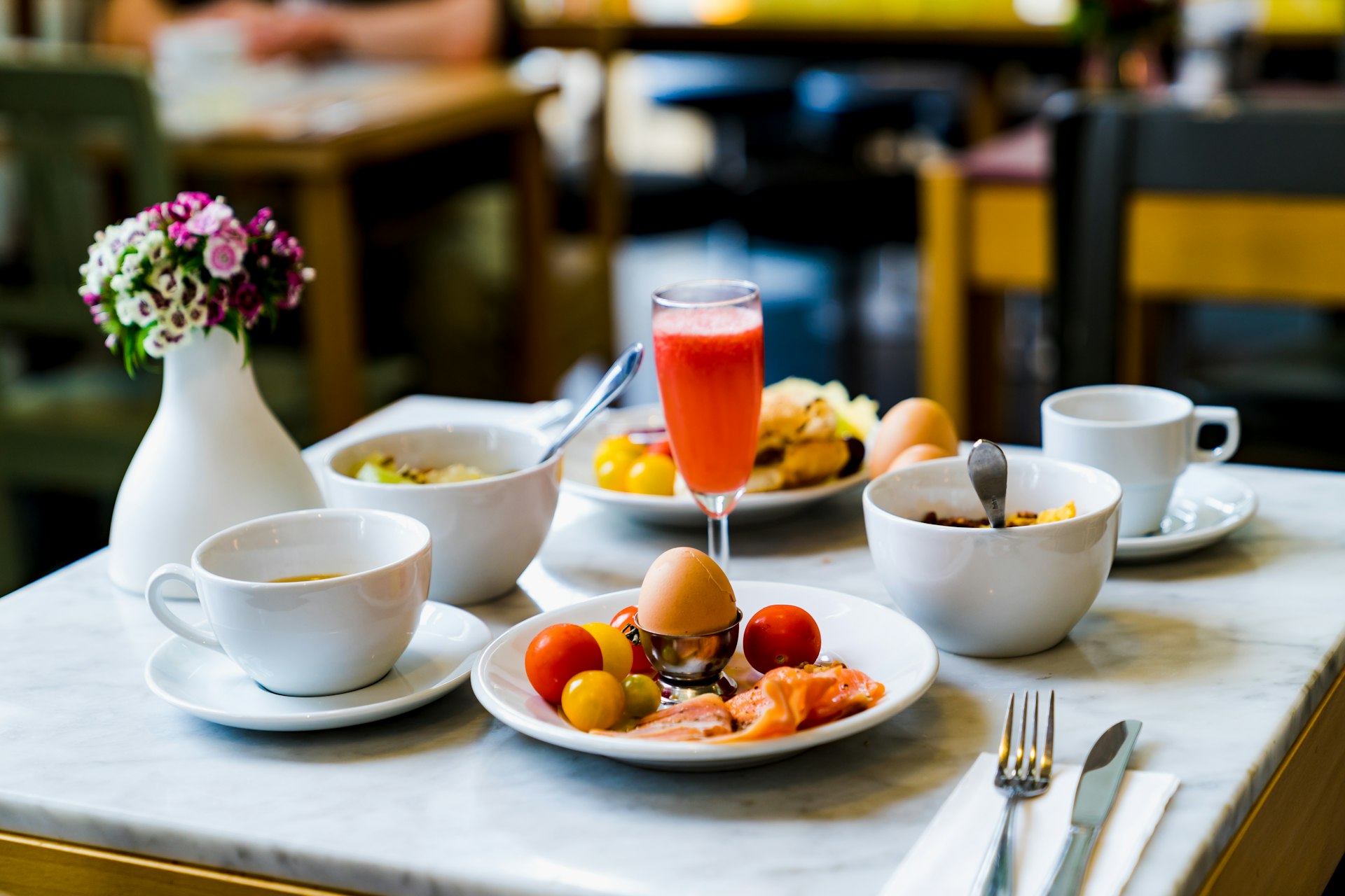 Gedeckter Frühstückstisch mit Kaffee, Saft und Obst