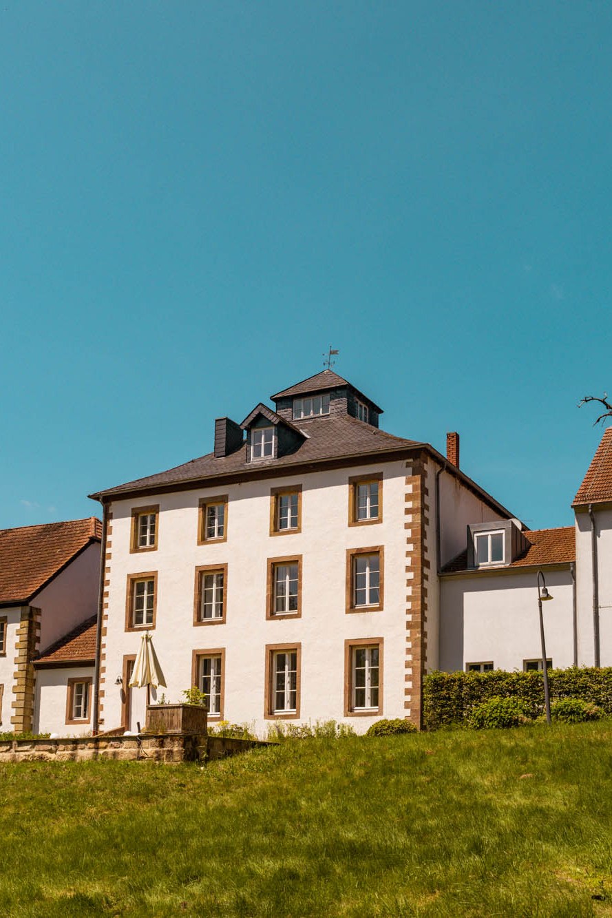 Historisches Herrenhaus des Hofguts Imsbach in Tholey unter blauem Himmel